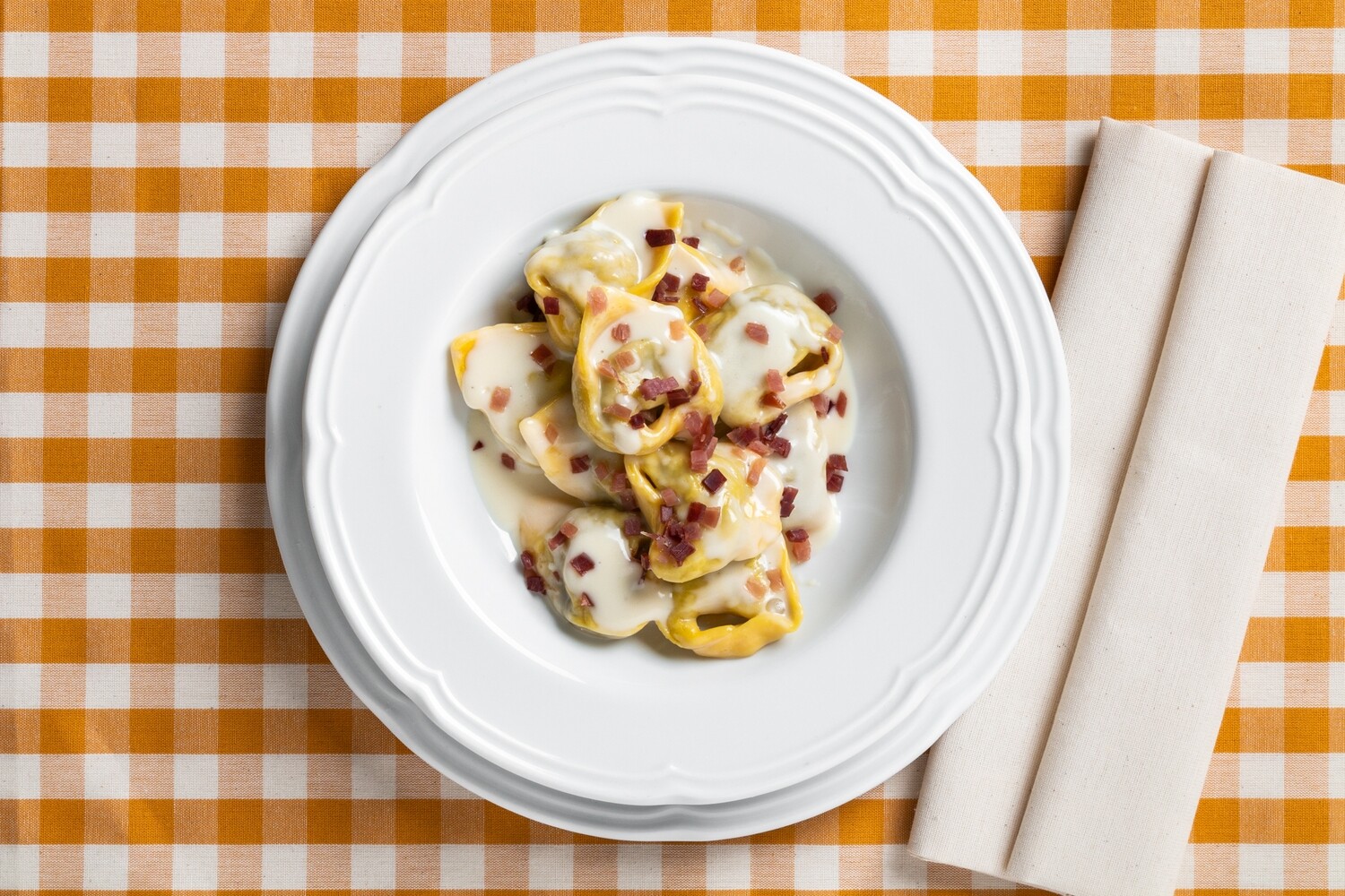 Tortelli ai porcini in crema di parmigiano e fiocco Tortelli ai porcini in crema di parmigiano e fiocco