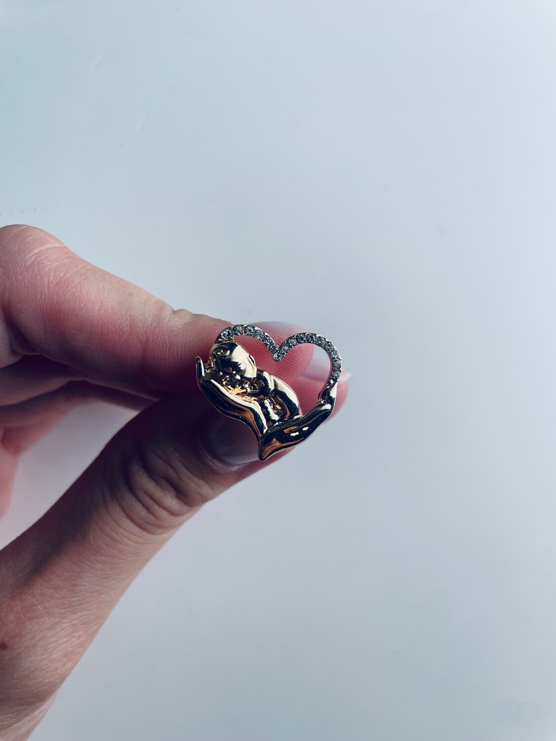 Kūdikis delnuose aukso spalvos