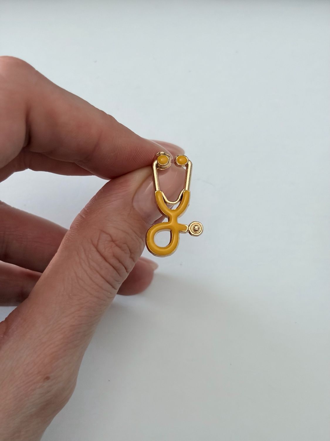 Sagė geltonas stetoskopas su aukso spalva