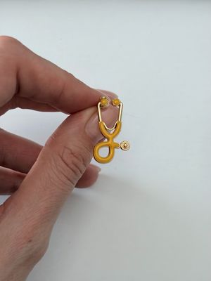 Sagė geltonas stetoskopas su aukso spalva