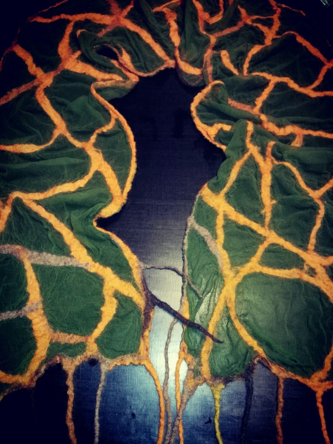 Felgroene sjaal met oranje details. Nunovilt.
