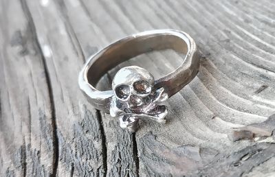 Anello con teschio e ossa incrociate, in bronzo o argento. 
