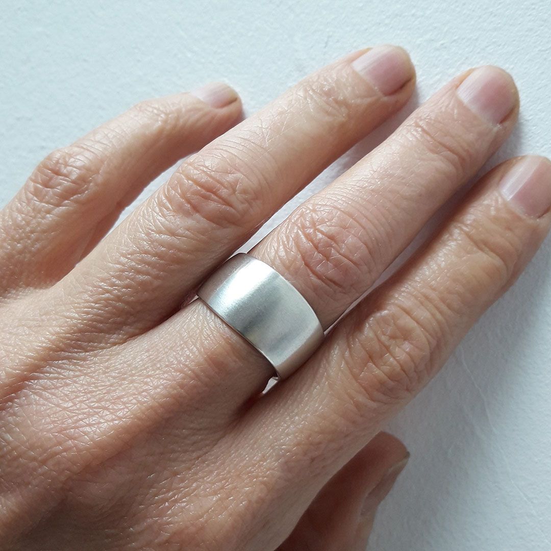 Anneau en argent 925 largeur 8 mm porté majeur main gauche.