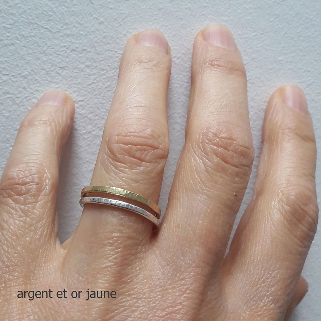 alliances fines en argent et or jaune portées à la main. Alliances fines en argent et or jaune, superposition élégante.