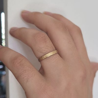 Alliance ruban martelée en or jaune 18 carats, largeur 3 mm, portée au doigt, façonnée à la main.