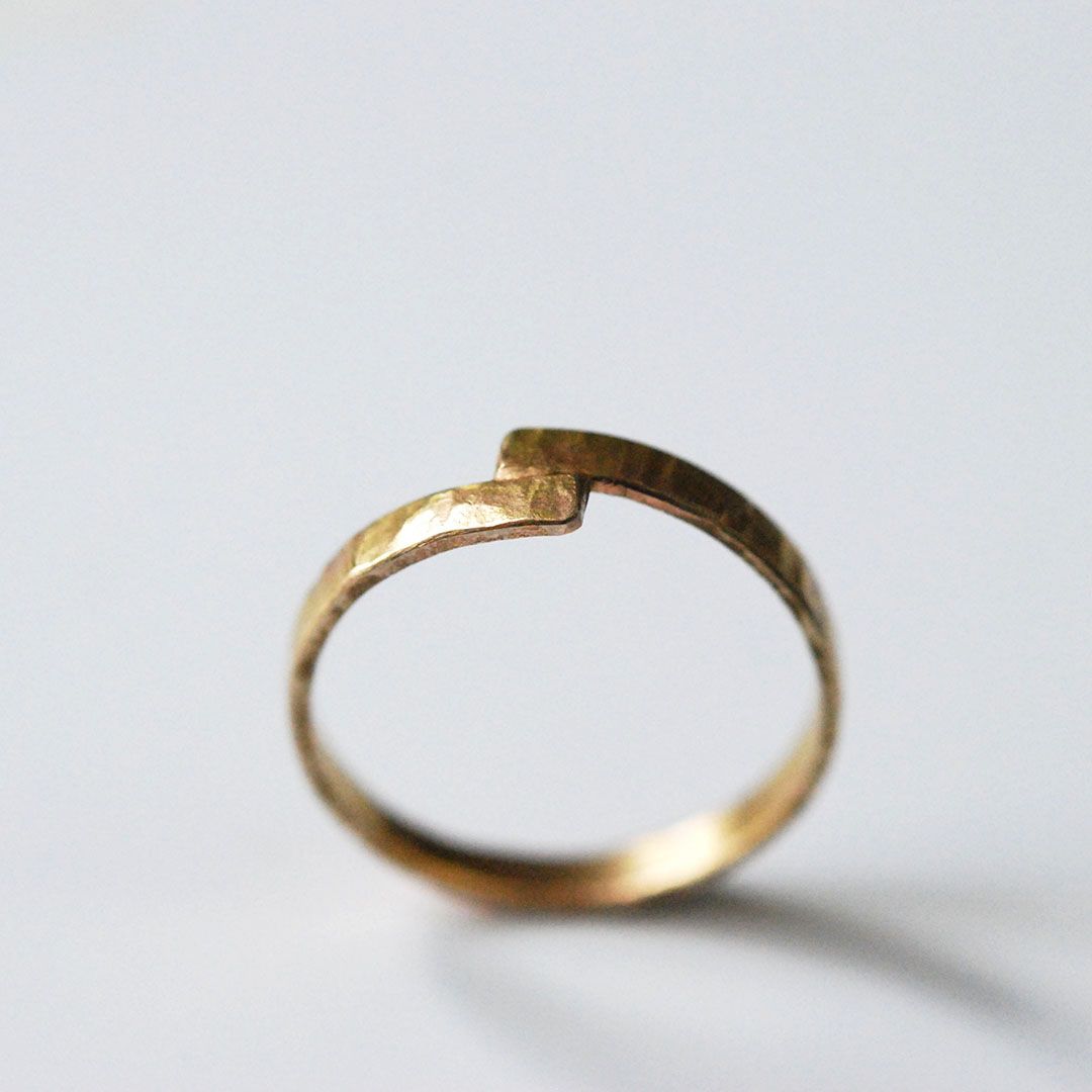 Alliance fine entrecroisée en or 18K, élégance intemporelle.
