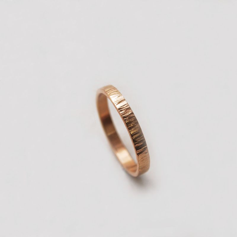 Bague alliance ruban plat martelée en or rose 18 carats, style mariage élégant. 