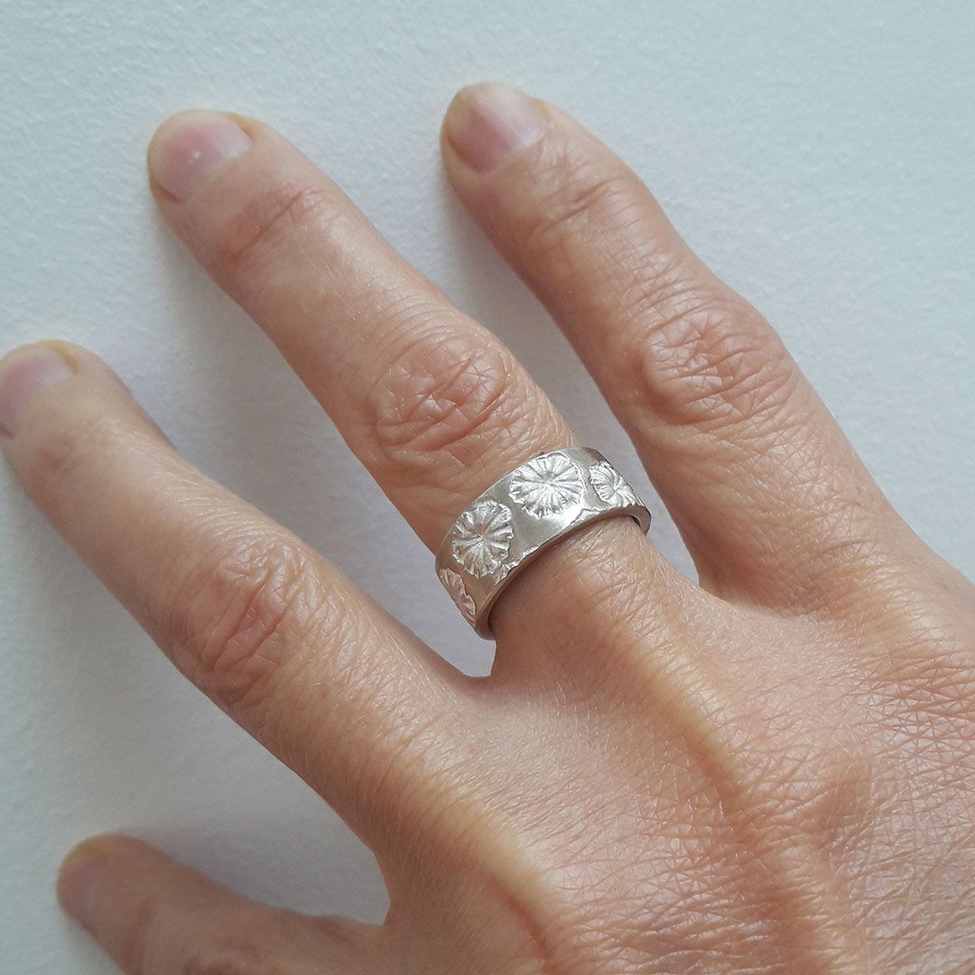 Anneau Pavots en argent 925 largeur 7 mm porté majeur main gauche.