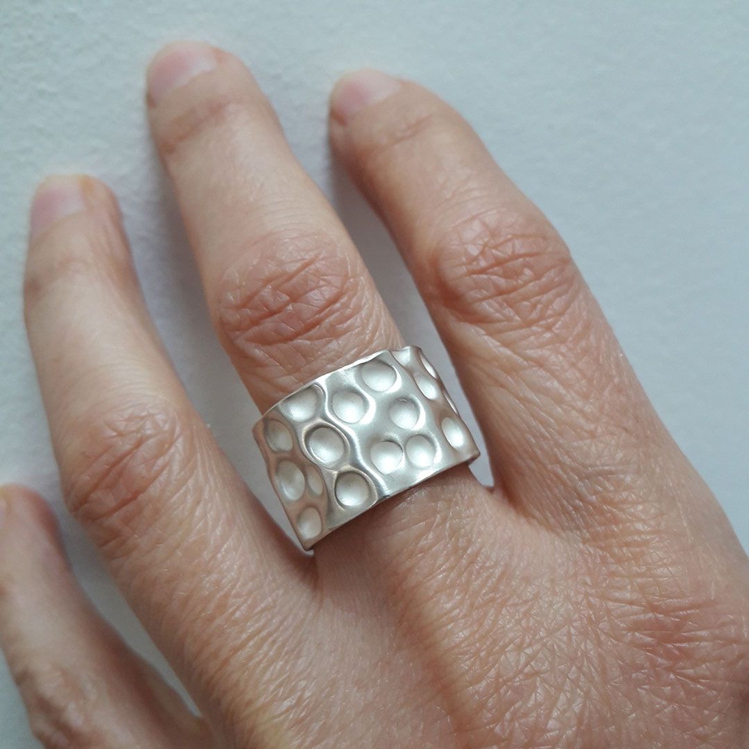 Bague large en argent 925 emboutie portée au doigt