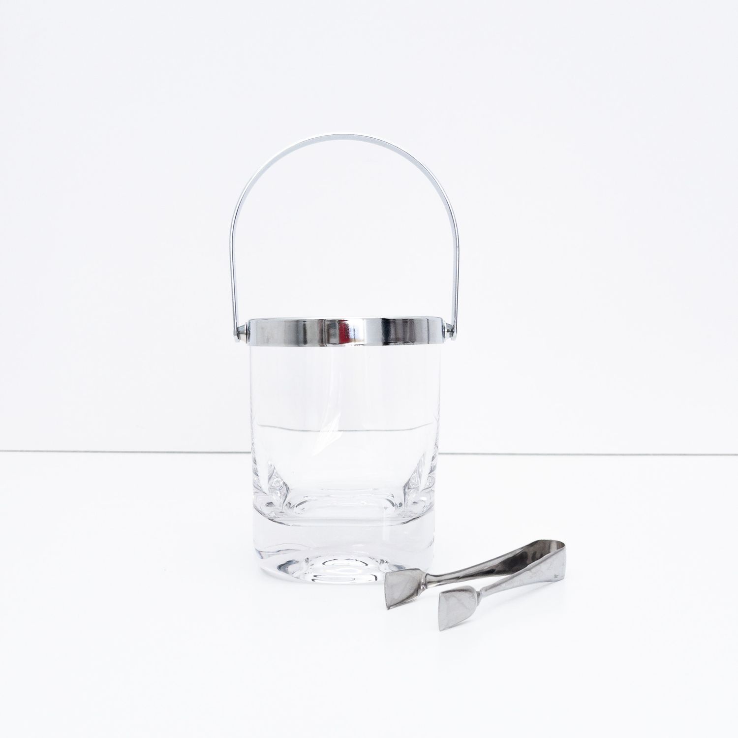Ice bucket with glass body and chrome metal trim and tongs
