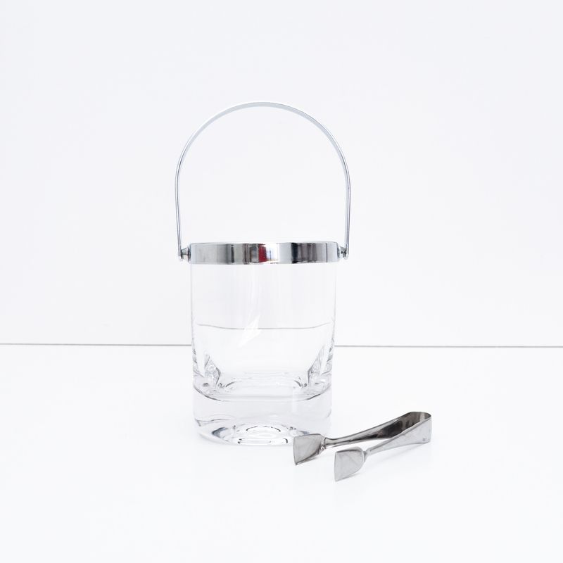 Ice bucket with glass body and chrome metal trim and tongs