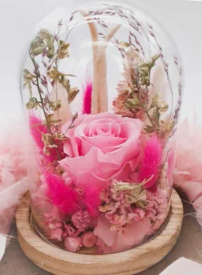 Eternal rose and dried flowers under a bell jar. Pink and natural color. Handmade.
