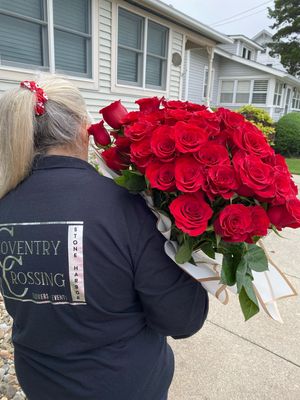 Coventry Crossing Florist staff carry a Hundred Roses Bouquet out for local fresh flower delivery in Stone Harbor NJ
