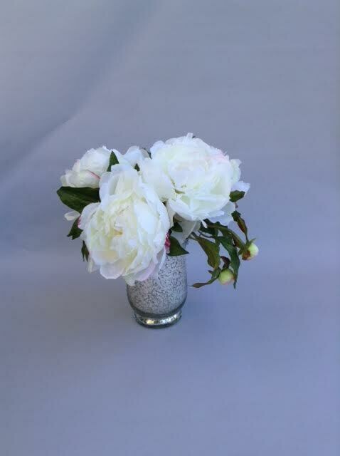 White peonies in a small mercury vase