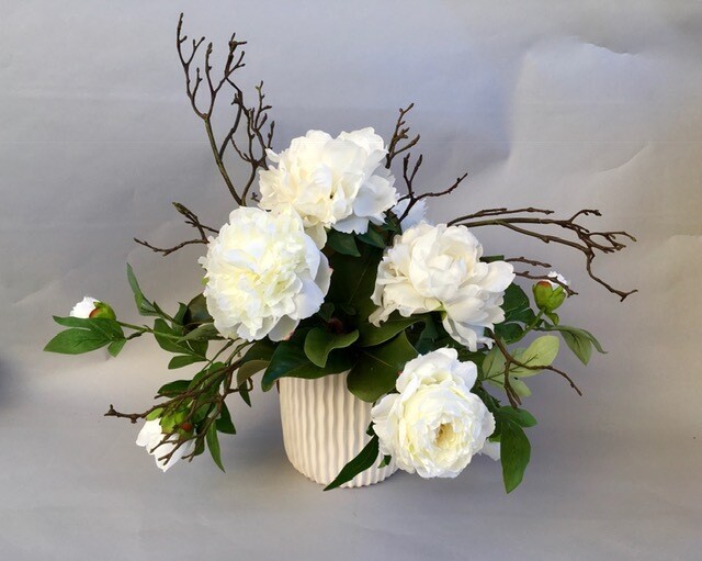 White peonies and branches in a white ceramic