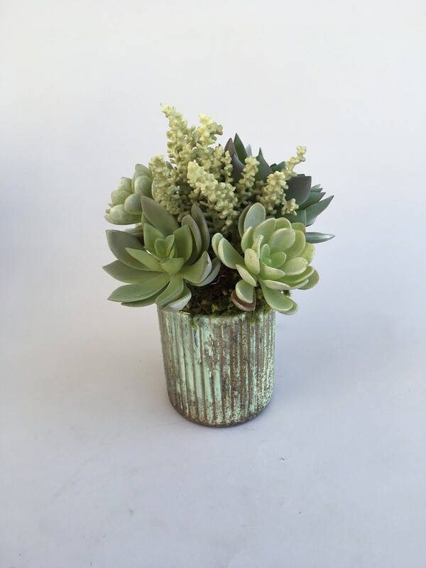 Dusty agaves and sedum succulents in a mercury patina vase