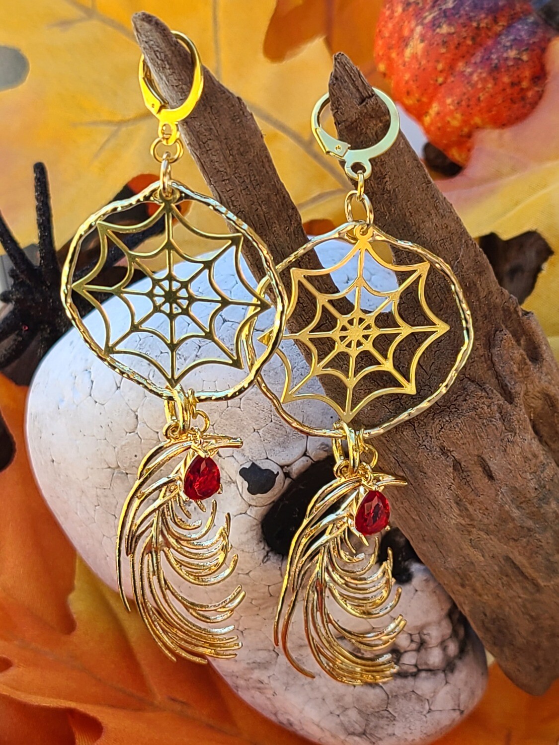 Gold-tone spiderwebs with red gems