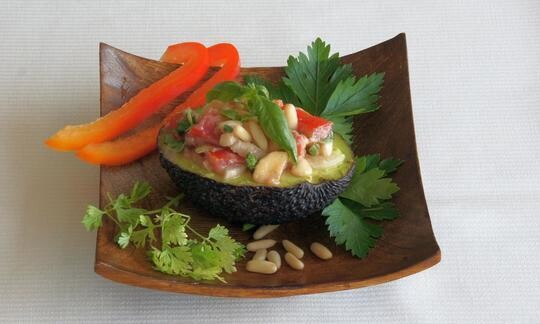 Aguacate relleno de tomate, plátano y piñones