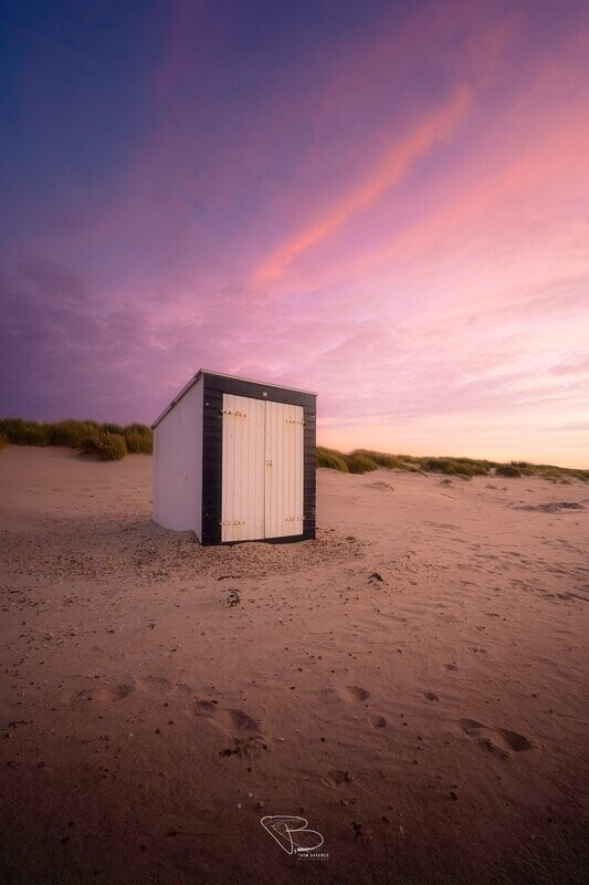 Strandhuisje onder kleurrijke hemel