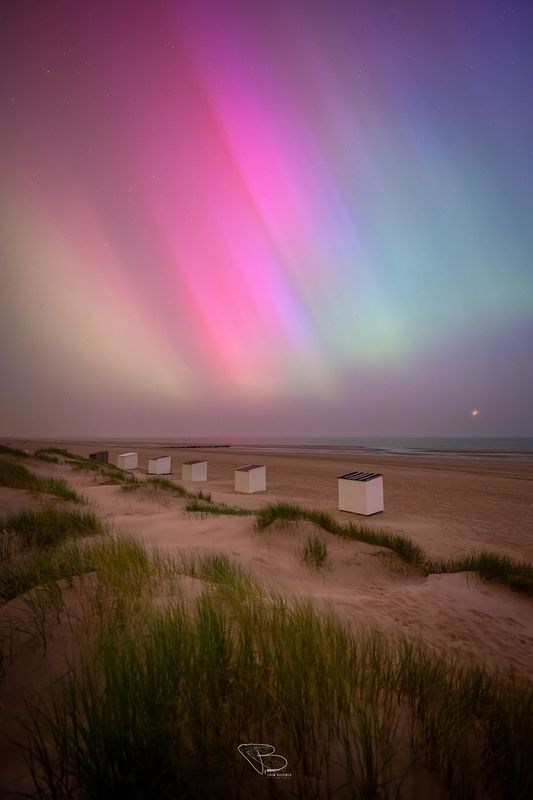 Strandhuisjes en duinen onder noorderlicht