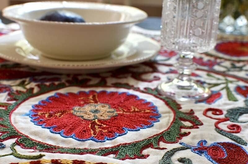 Red suzani fabric table runner with a turtle