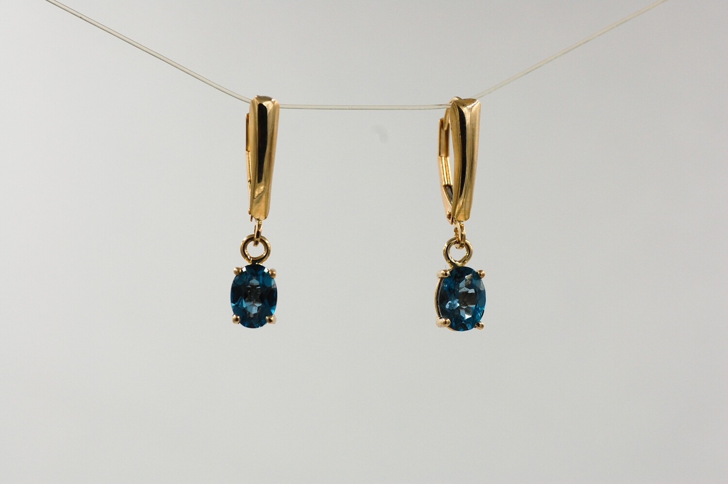 Oval 7x5mm London Blue Topaz dangle earrings - 14ky