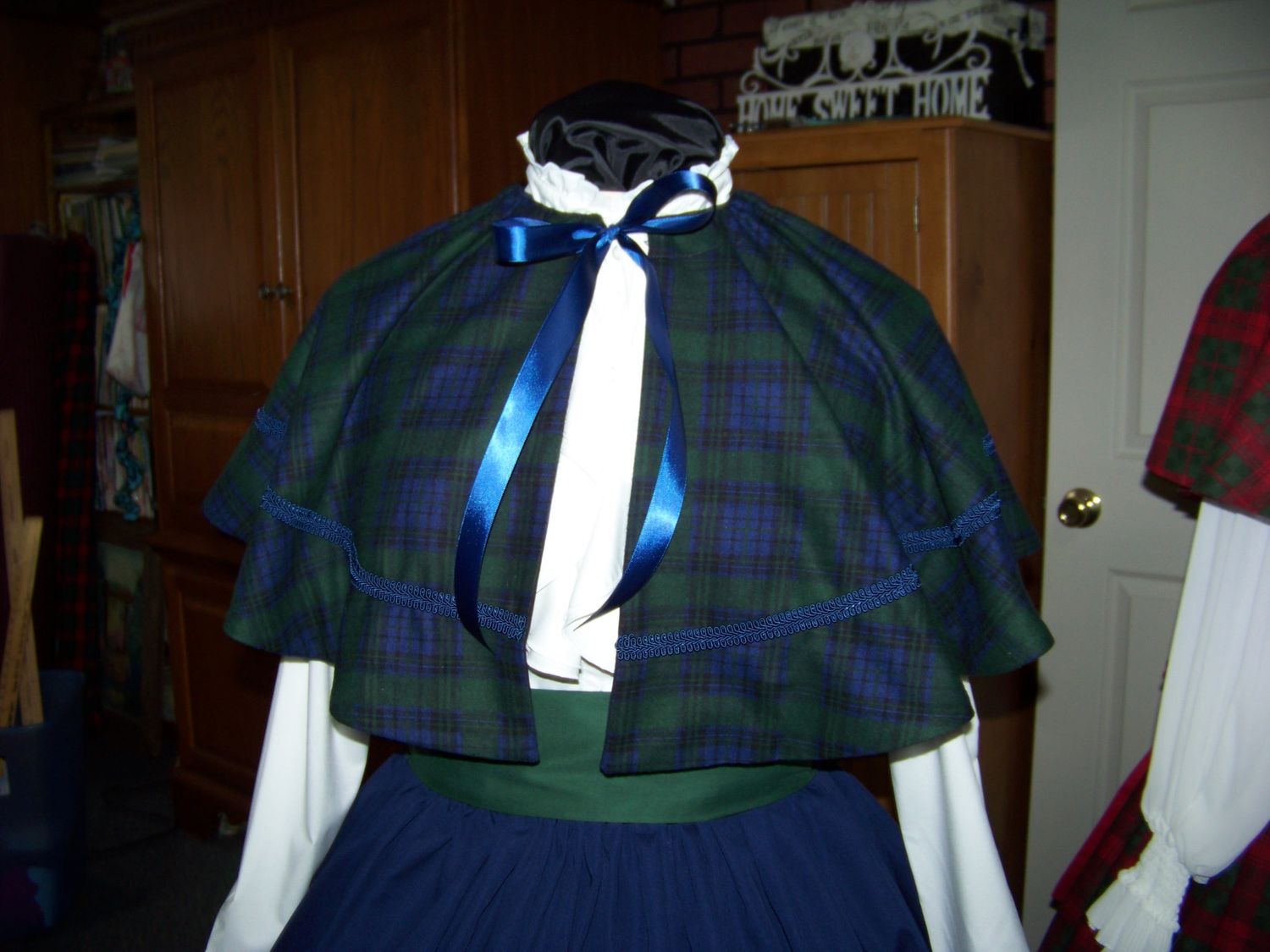 Dicken&#39;s Christmas Caroler cape Navy blue and black and green Plaid cape reversible Navy blue solid on back one size fits most with Navy blue Skirt and green sash