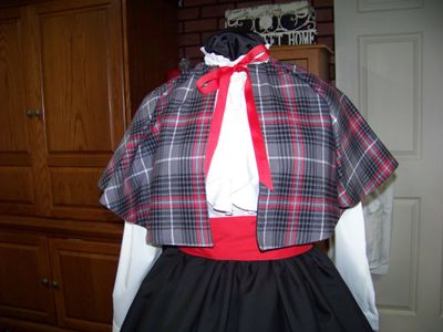 Dicken&#39;s Christmas Caroler cape Red and black and gray Plaid flannel cape reversible with black on back one size fits most with Black Skirt and red sash. Handmade in USA