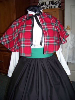 Dicken's Christmas Caroler cape Red, green, white and black Plaid Flannel cape reversible black solid on back one size fits most with Black Skirt and green sash. Handmade USA