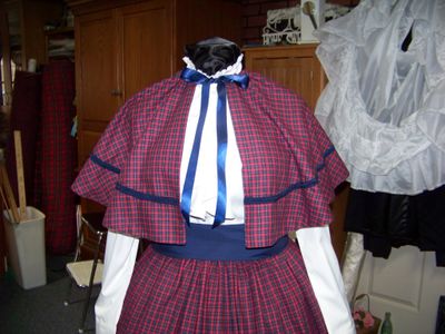 Dicken's Christmas 3-piece outfit Navy-Blue, Cranberry and yellow small checked flannel skirt and cape with solid Navy-blue sash and lining and braid trim.