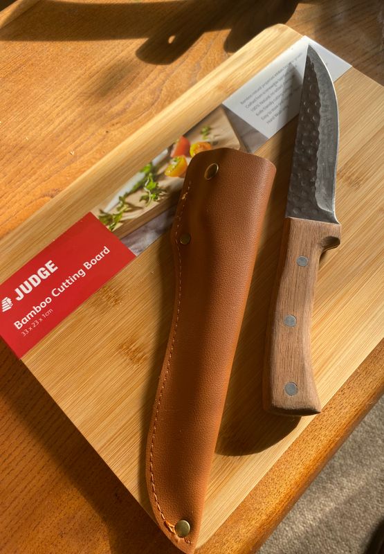 Wooden chopping board with knife and spices