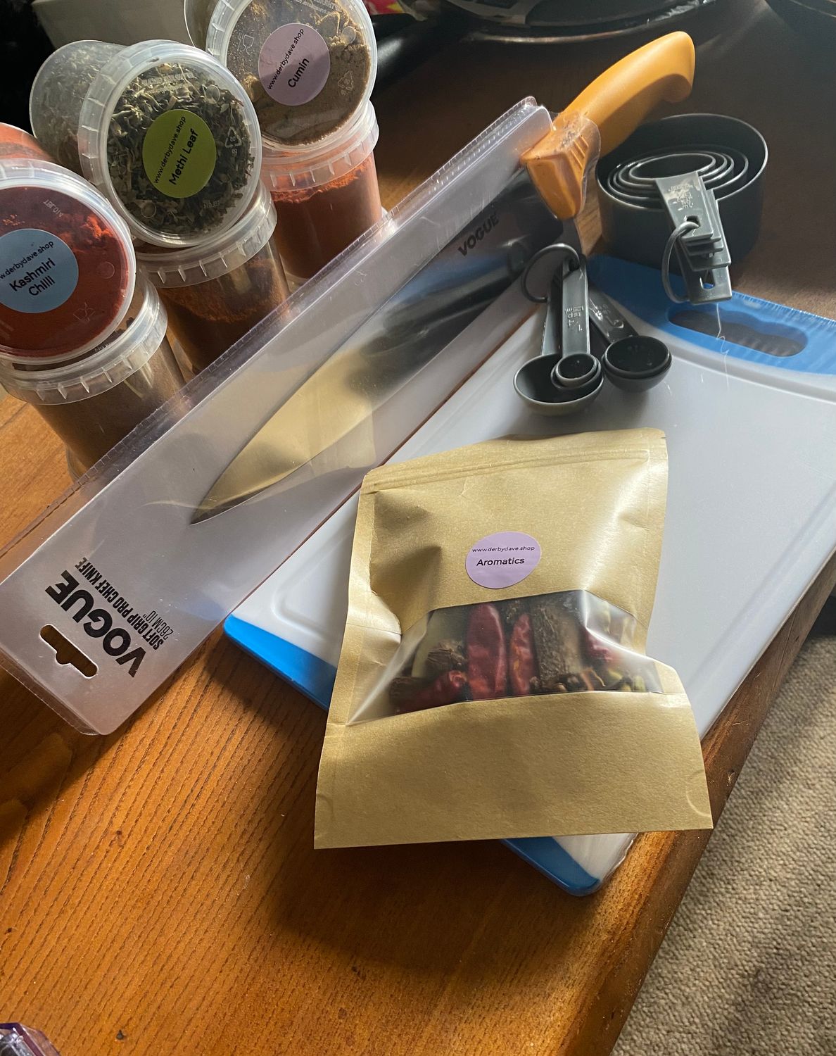 Professional chef knife, measuring cups and spoons, mega spice selection and a chopping board