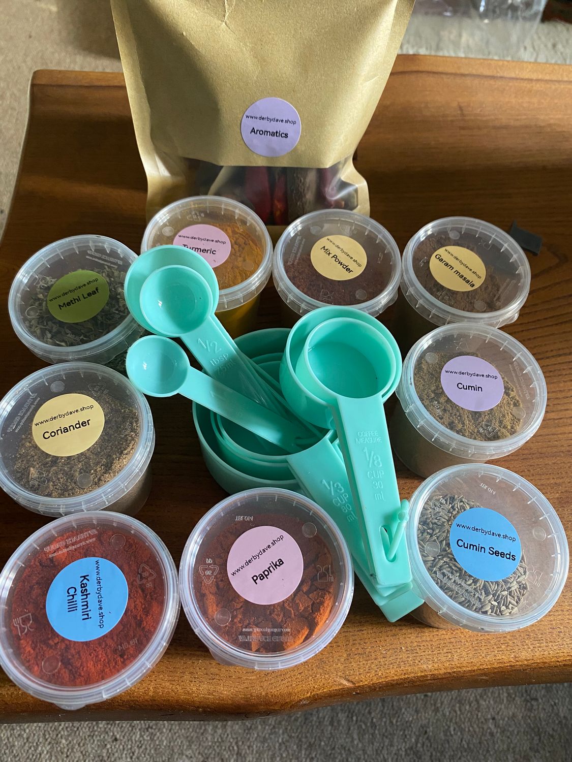 Spice kit with green measuring spoons and measuring cups