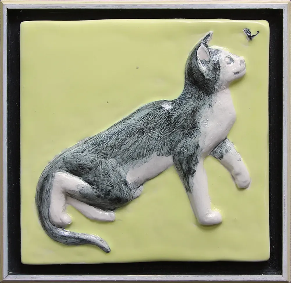 framed ceramic feature tile depicting a pretty grey cat chasing a fly. 15cms x 15cms