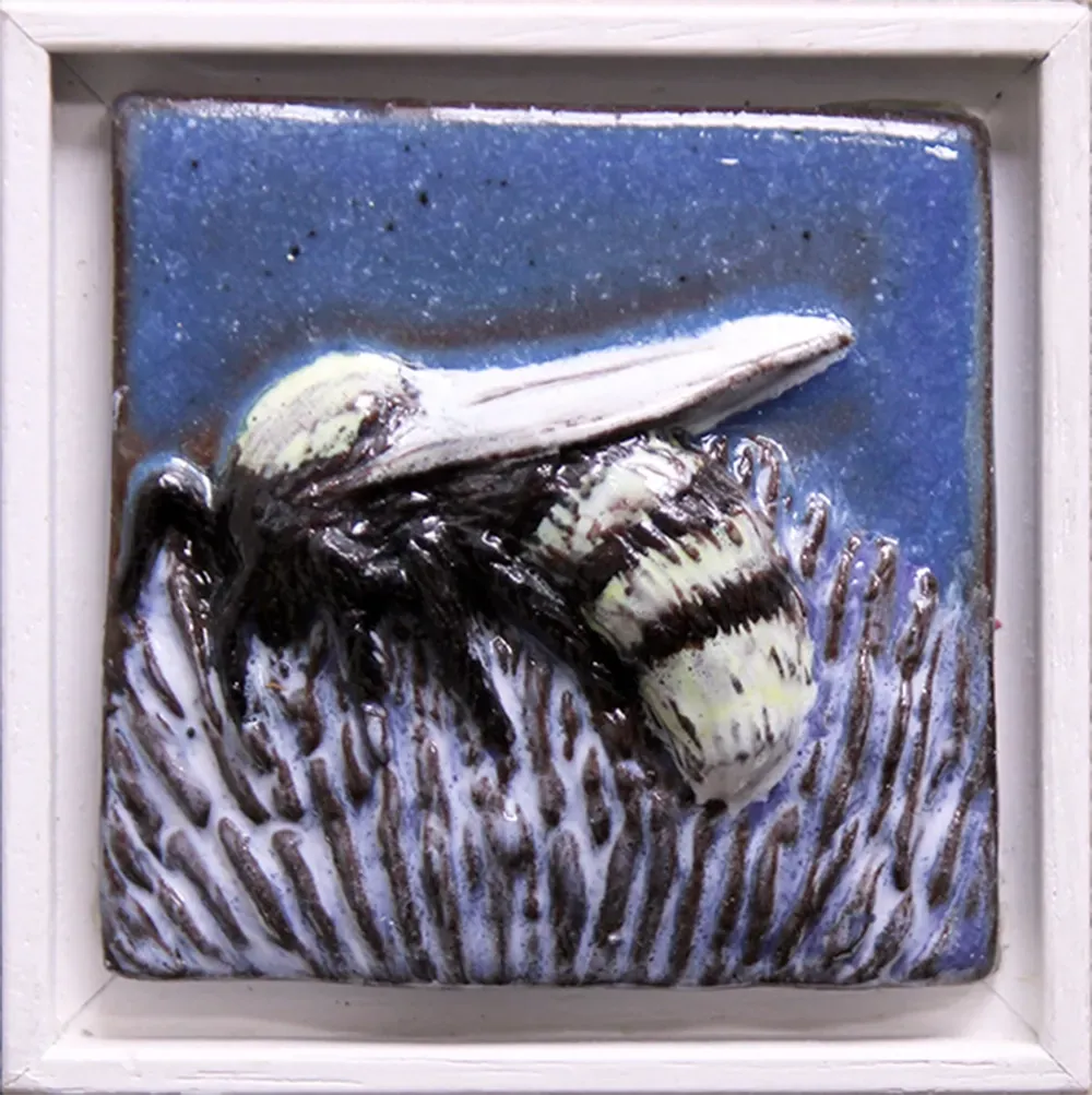 A white framed blue feature tile depicting an under-glazed bee with a transparent glaze covering. 8.5cm x 8.5cm