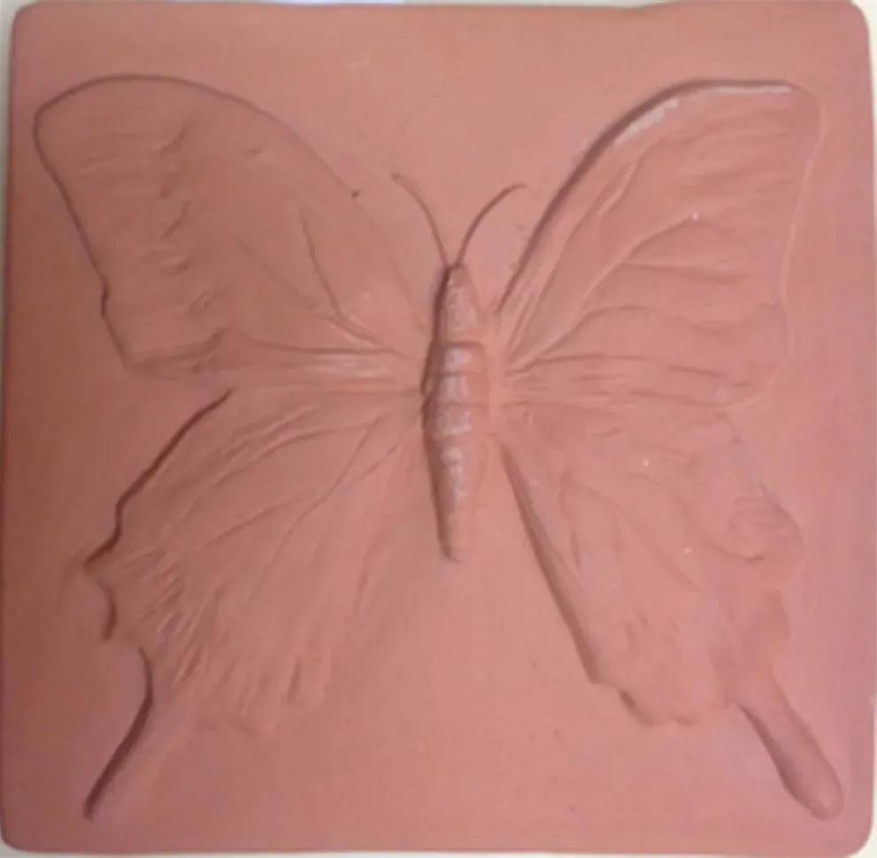 Unglazed feature terracotta tile depicting a swallowtail butterfly 9.2cm x 9.3cm