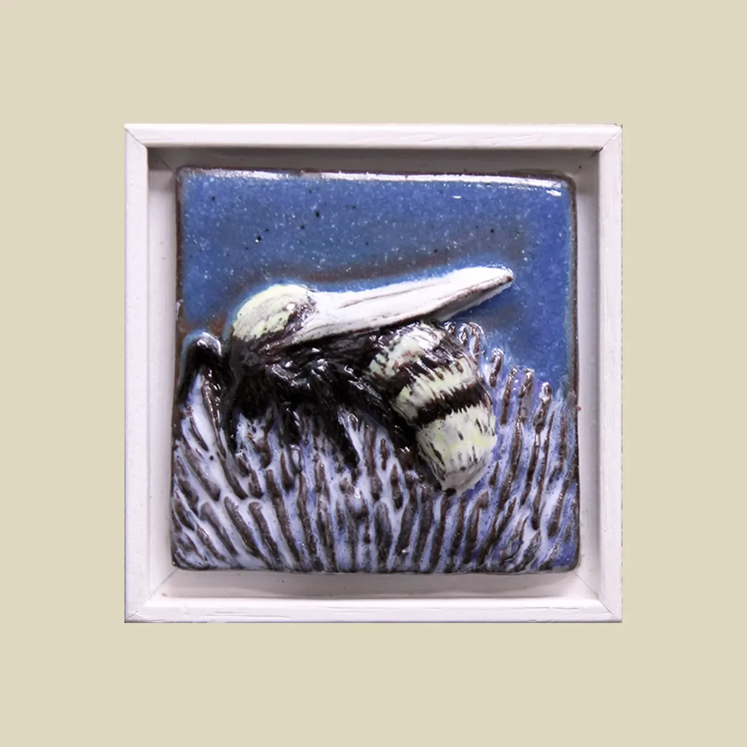 A white framed blue feature tile depicting an under-glazed bee with a transparent glaze covering. 8.5cm x 8.5cm