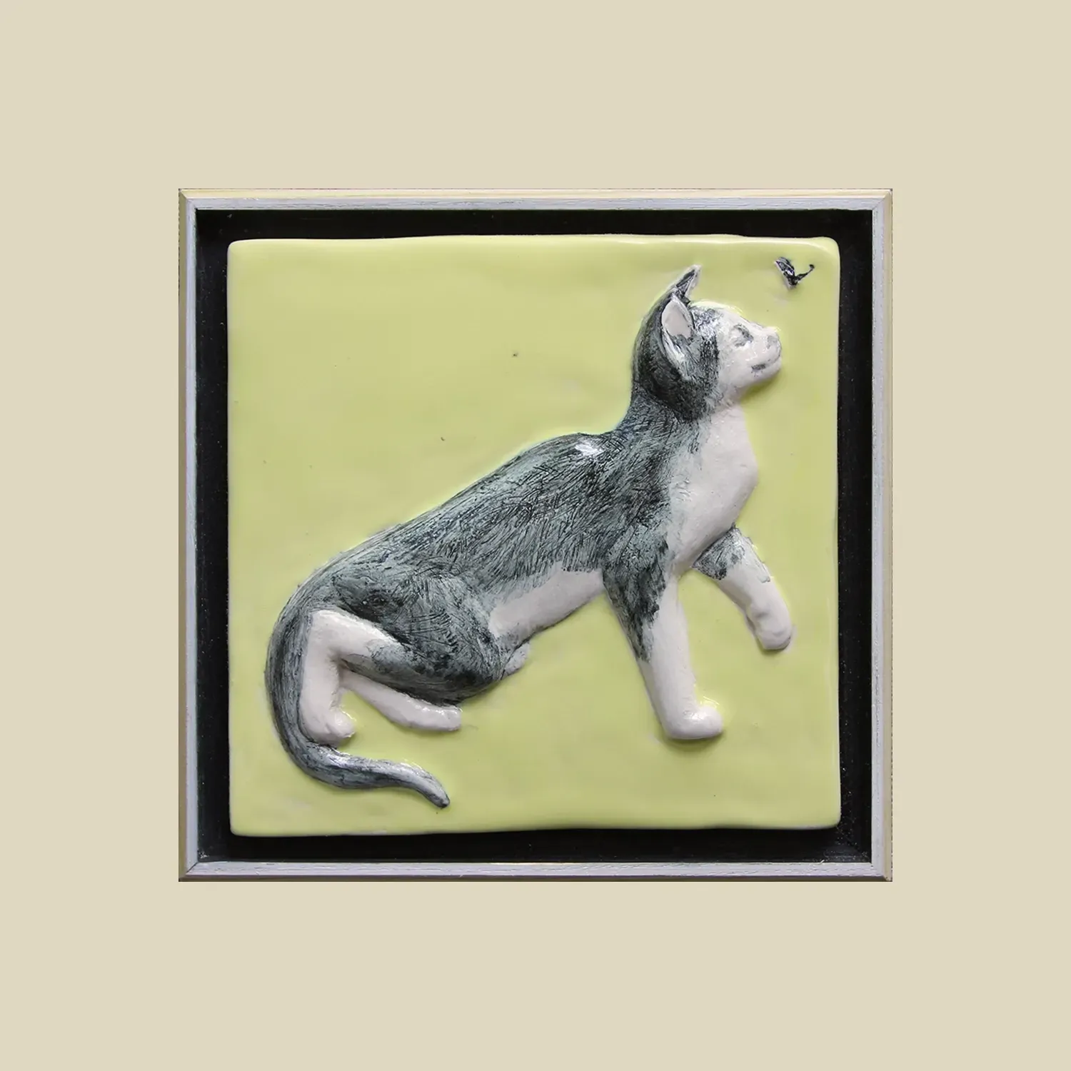 framed ceramic feature tile depicting a pretty grey cat chasing a fly. 15cms x 15cms