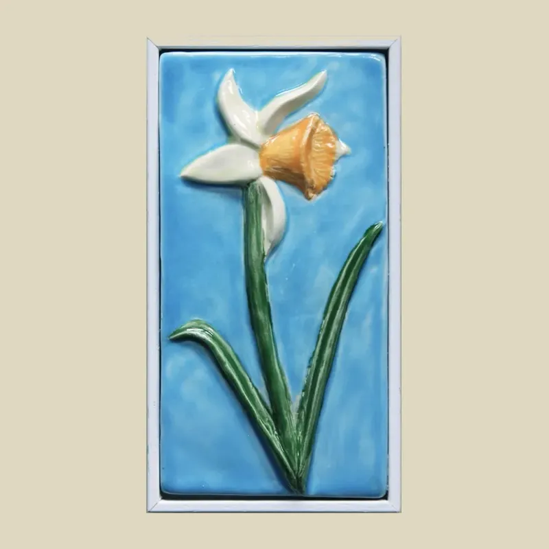 white framed sky blue tile featuring an orange trumpeted daffodil