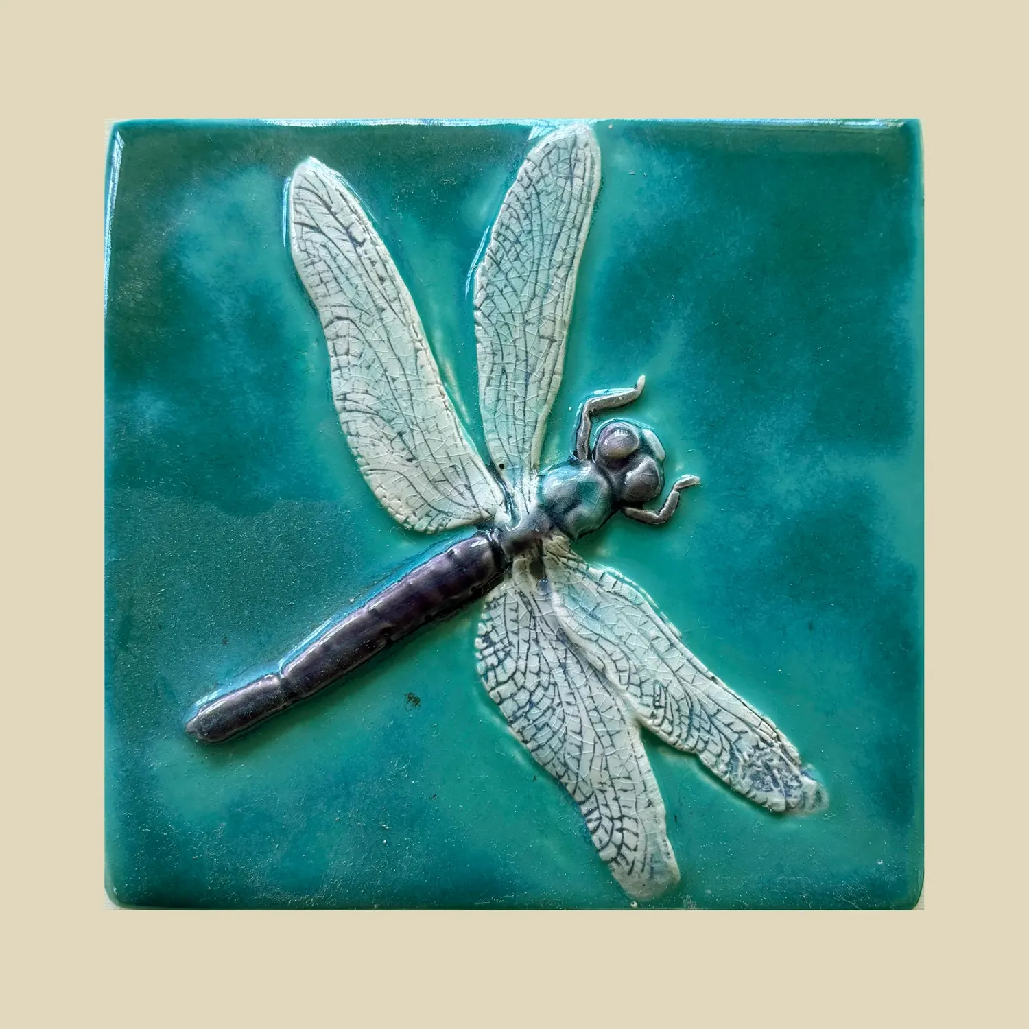 A delicate dragonfly with a dark purple body on a jade green background. 11.5cms x 12cms