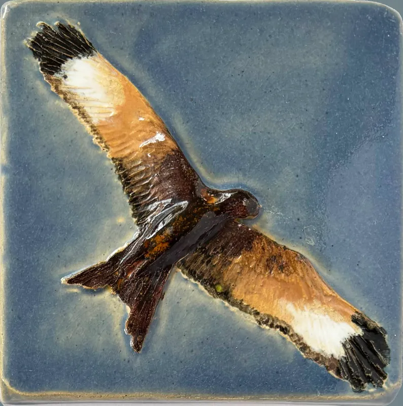 A ceramic feature tile, showing a stunning red kite in flight set against a grey blue background, measuring 12cm x 12cm