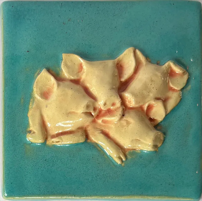 A ceramic feature tile, showing a  group of pigs huddled together set against a turquoise green background 10cm x 10cm