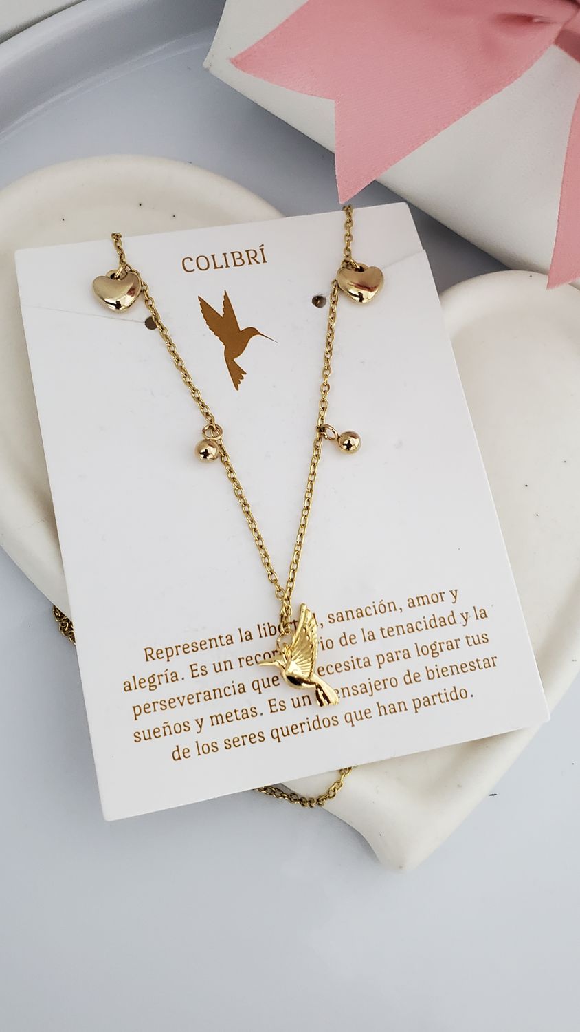 Tarjeta con collar , dijes corazones y colibri en acero dorado.