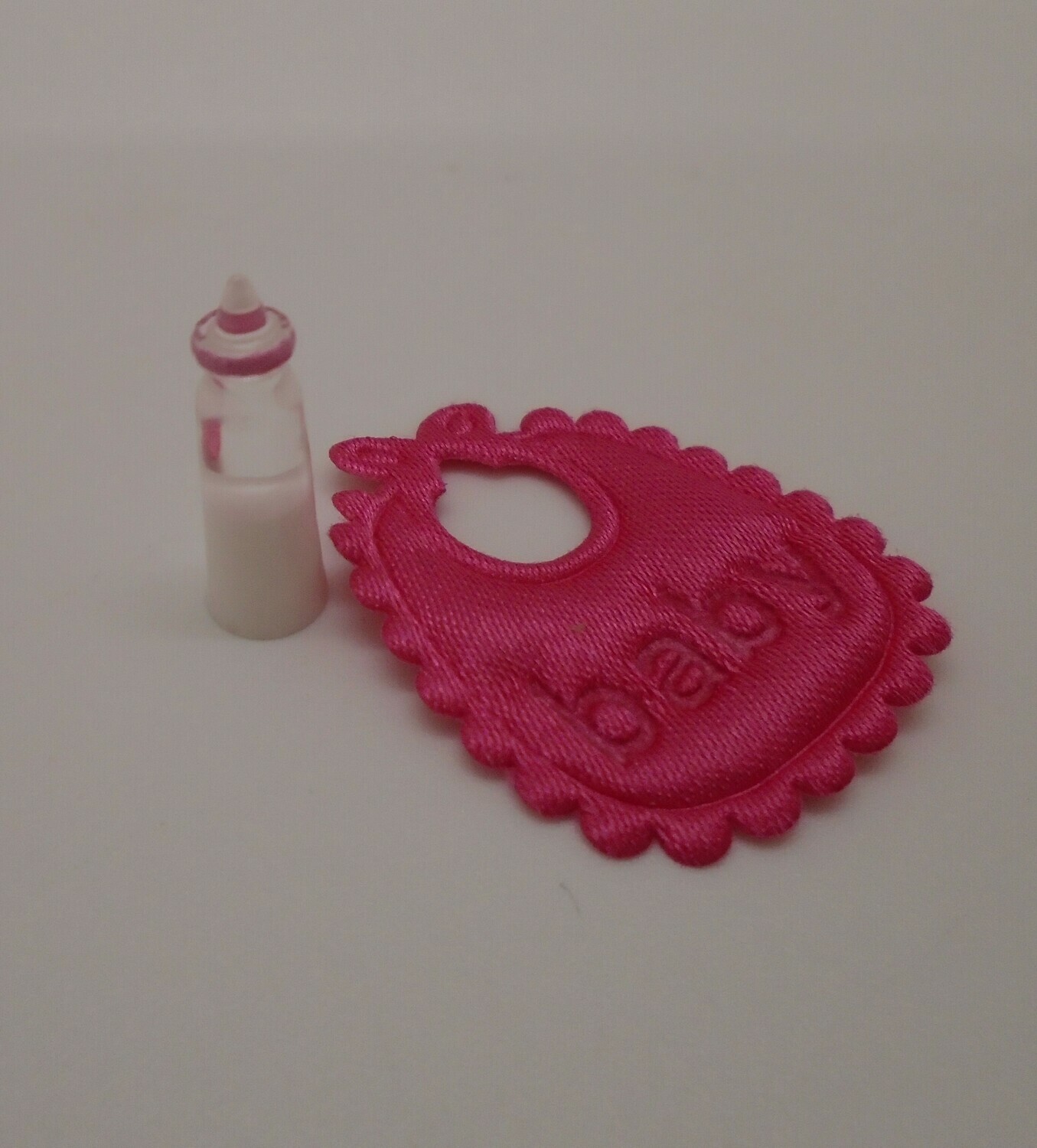 PINK BIB AND BOTTLE OF MILK