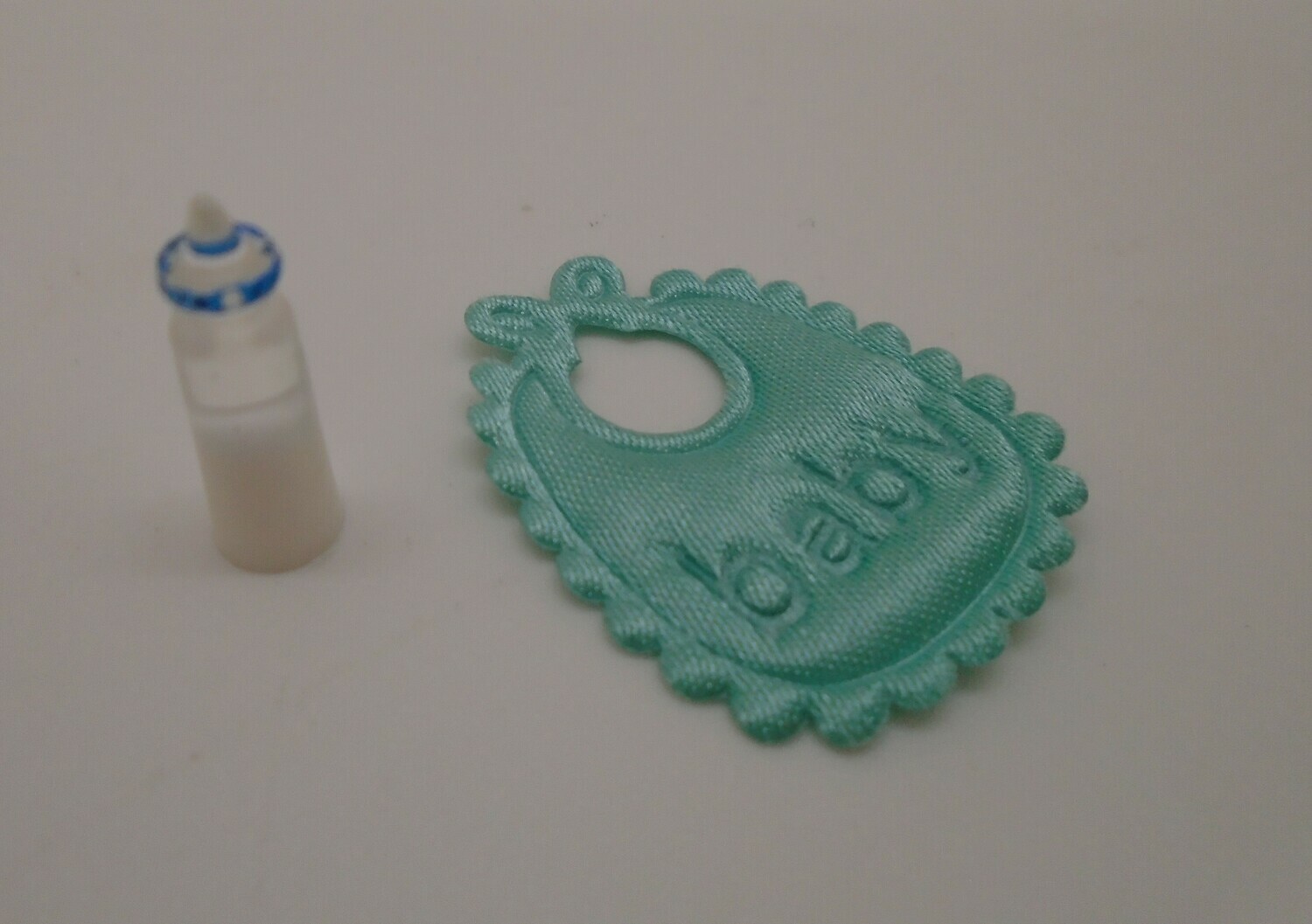 GREEN BIB AND BOTTLE OF MILK