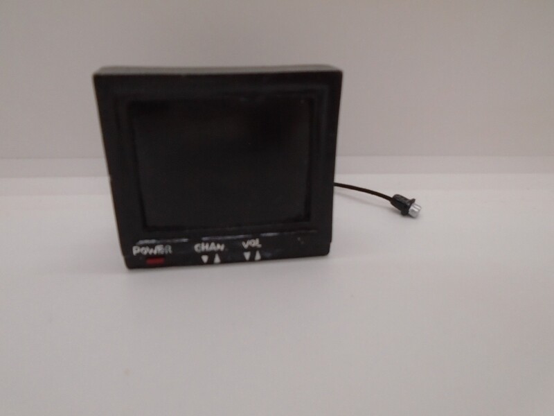 BLACK TV WITH PLUG AND DETAIL ON REVERSE