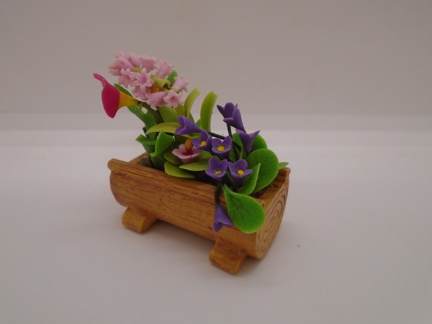 FLOWERS IN LOG TYPE CONTAINER