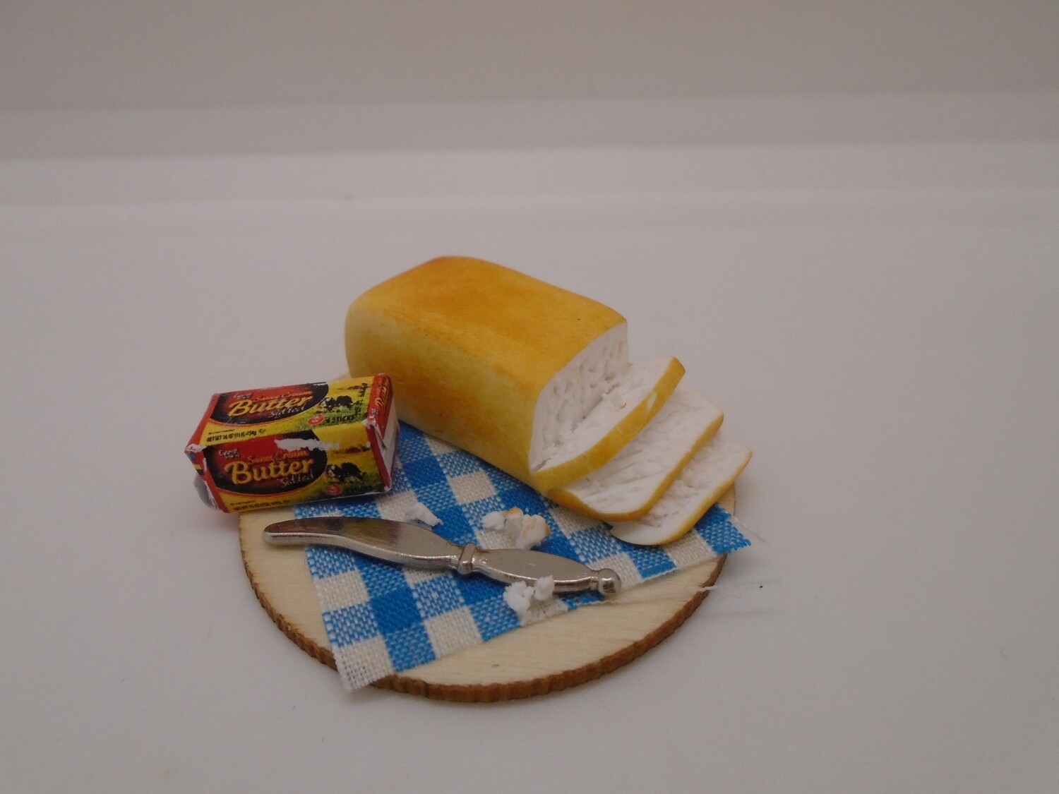 BREAD ON BOARD WITH CRUMBS,BUTTER AND KNIFE