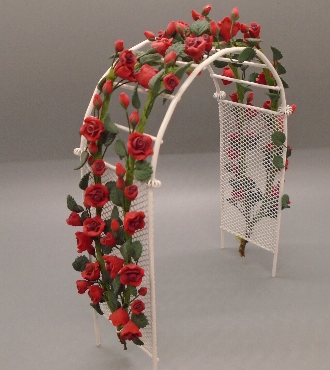WHITE WIRED GARDEN ARCH WITH CLIMBING RED ROSES