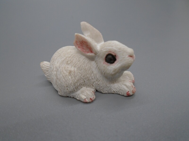 WHITE RABBIT LYING WITH EARS DOWN